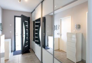 un hall d'entrée lumineux avec placard vitré